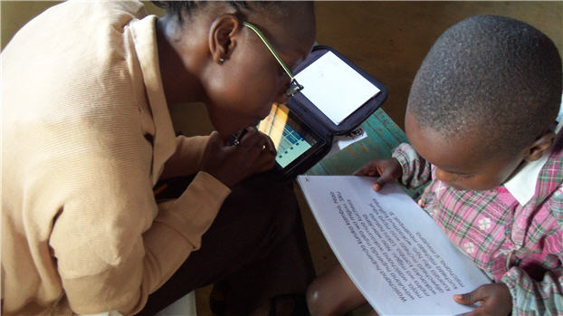 Photo showing a teacher using Tangerine to record student reading test results in Kenya.